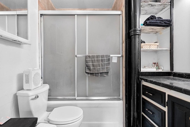 full bathroom featuring vanity, shower / bath combination with glass door, and toilet