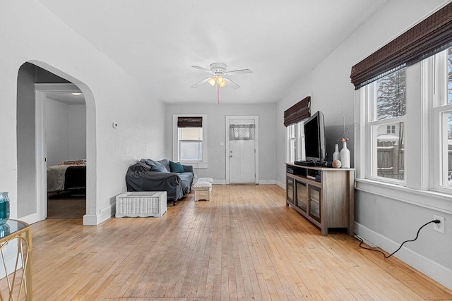 living room with ceiling fan, a healthy amount of sunlight, and light wood-type flooring