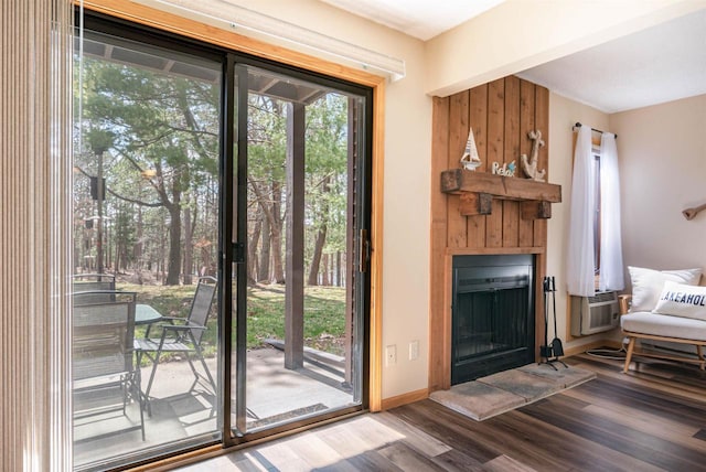 doorway to outside with hardwood / wood-style flooring and a large fireplace