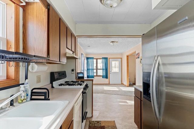 kitchen featuring stainless steel fridge with ice dispenser, range with gas cooktop, sink, and dishwasher