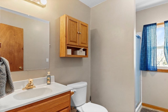 bathroom featuring vanity, an enclosed shower, and toilet