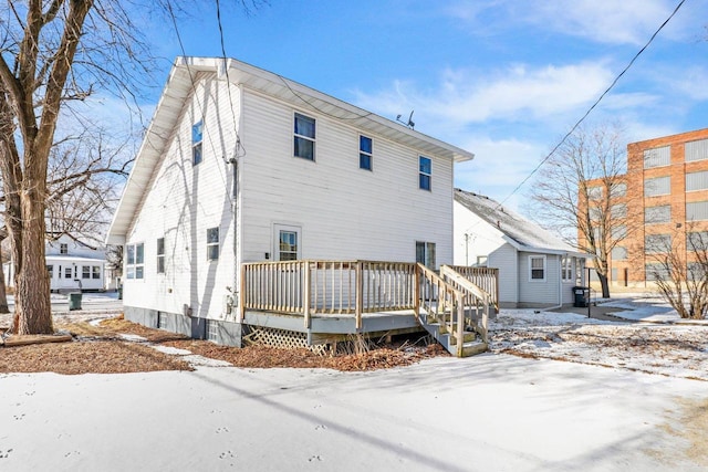 snow covered house with a deck