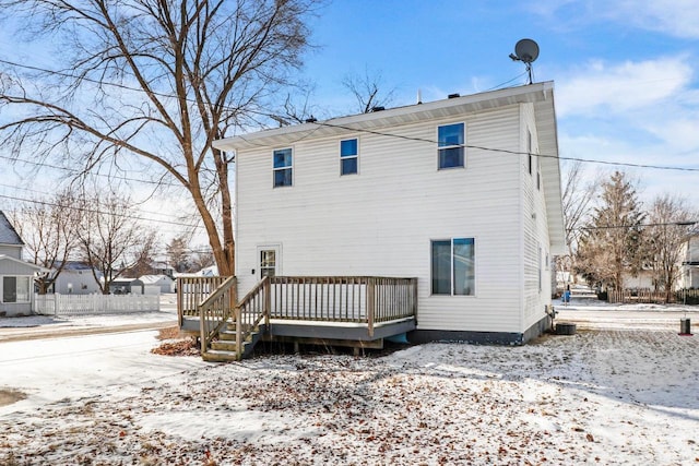 snow covered property with a deck