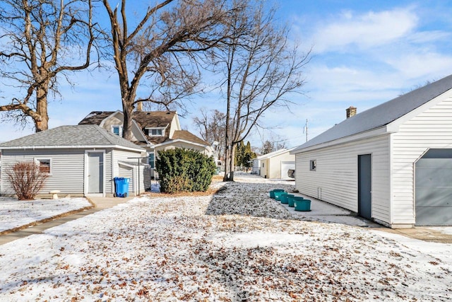 snowy yard with a garage