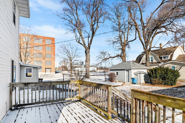 snow covered deck featuring an outbuilding