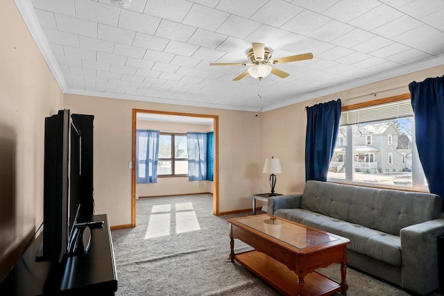 carpeted living room featuring ornamental molding and ceiling fan