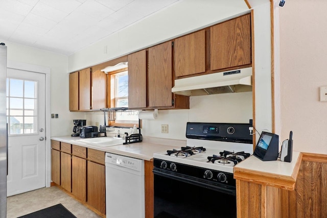 kitchen with gas range, white dishwasher, and sink