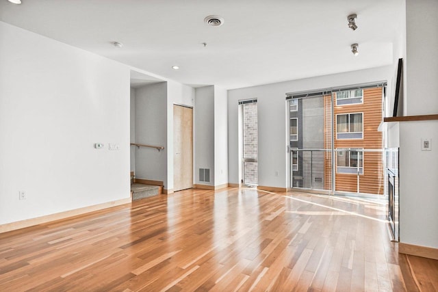 unfurnished room with a fireplace and light hardwood / wood-style floors