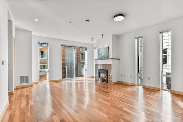 unfurnished living room featuring a fireplace and light hardwood / wood-style flooring