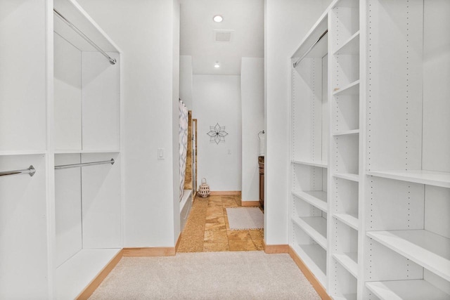 spacious closet featuring light carpet