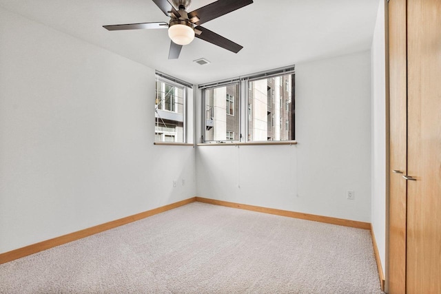 carpeted spare room featuring ceiling fan