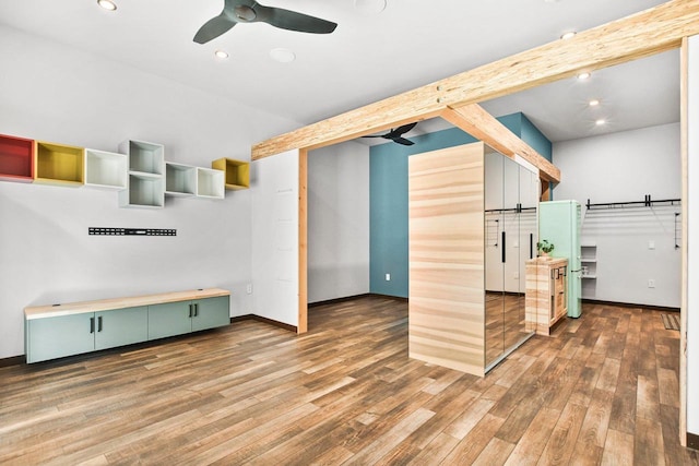 unfurnished living room with hardwood / wood-style flooring, ceiling fan, and beamed ceiling