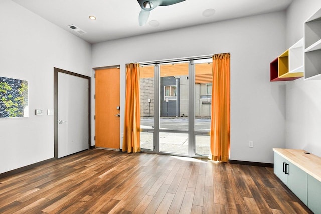 spare room with dark wood-type flooring and plenty of natural light