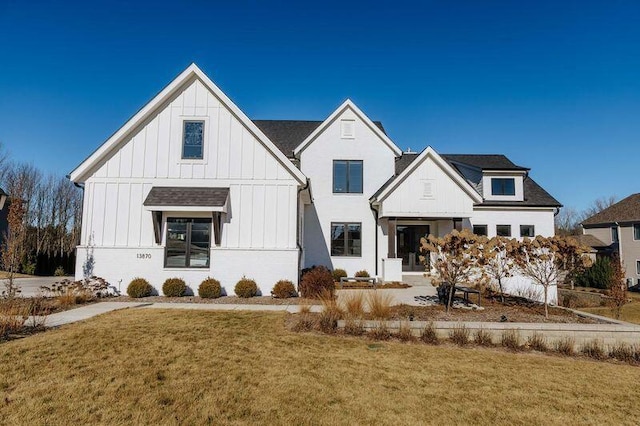 modern farmhouse style home with a front lawn