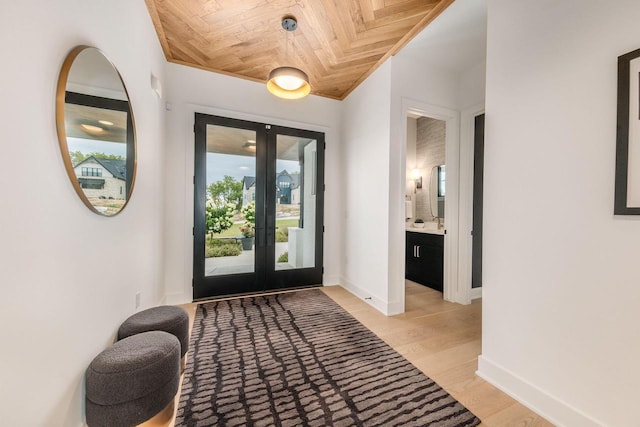 entrance foyer featuring wood ceiling, french doors, and light wood-type flooring