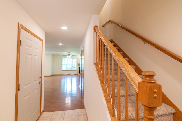 stairway featuring tile patterned floors and ceiling fan