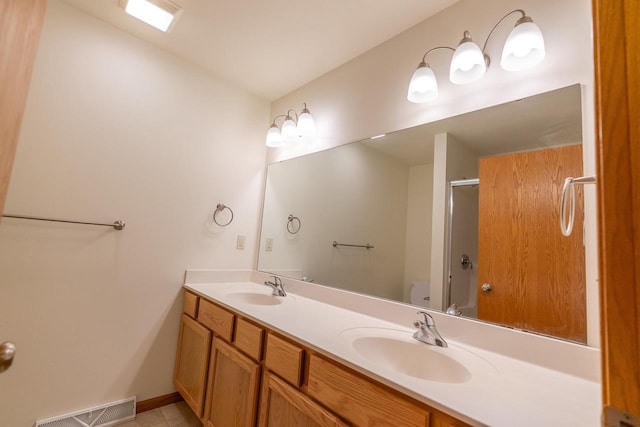 bathroom with toilet, vanity, and a shower with shower door