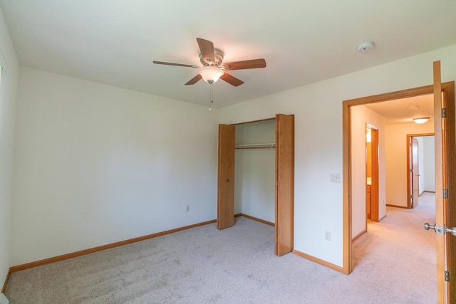 unfurnished bedroom featuring light carpet, ceiling fan, and a closet