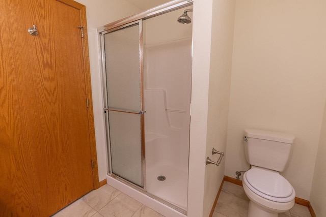 bathroom with tile patterned flooring, a shower with door, and toilet