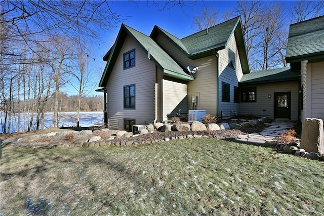 view of side of home featuring cooling unit, a yard, and ac unit