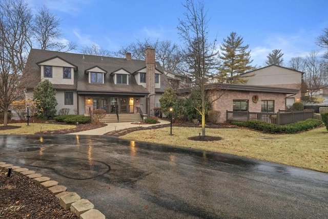 view of front of property featuring covered porch and a front lawn