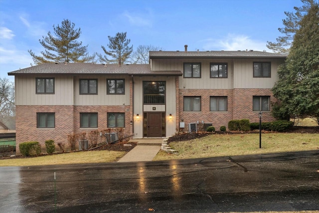 view of front of home featuring central AC unit and a front lawn