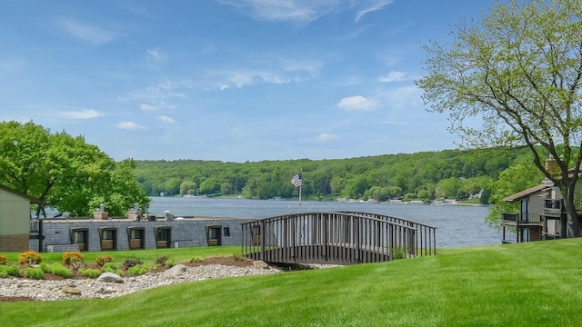 view of dock with a water view and a lawn