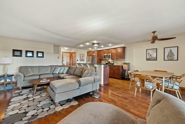 living room featuring dark wood-type flooring and ceiling fan