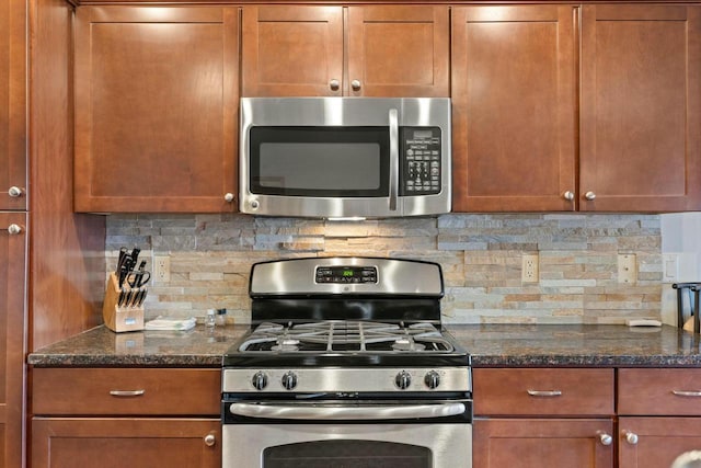 kitchen featuring dark stone countertops, decorative backsplash, and stainless steel appliances