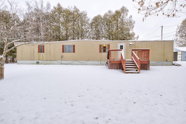 snow covered house with a deck