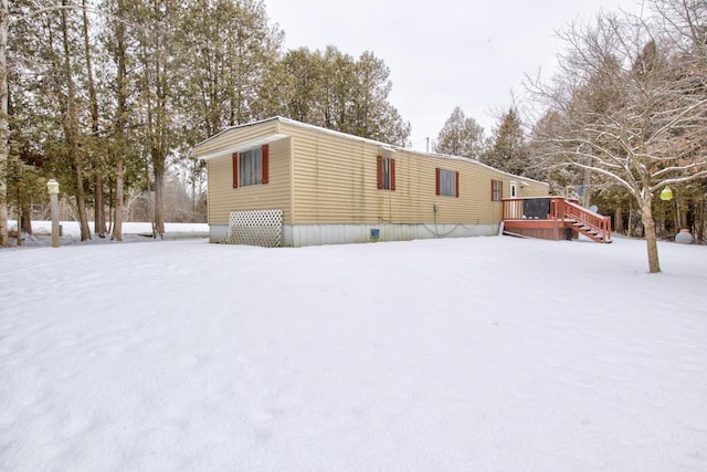 view of snowy exterior featuring a wooden deck