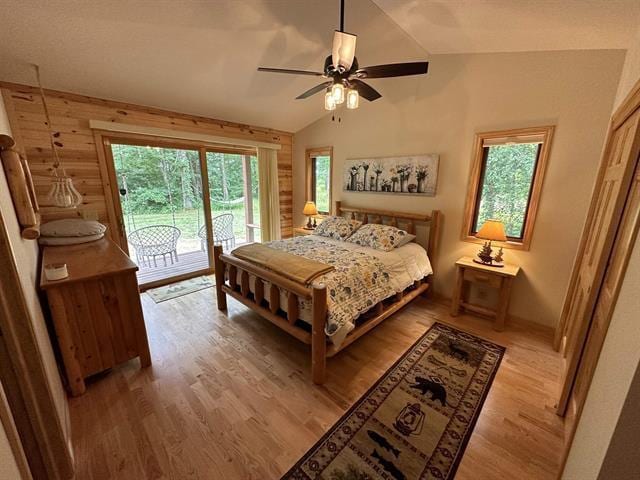 bedroom featuring ceiling fan, access to exterior, vaulted ceiling, and light wood-type flooring