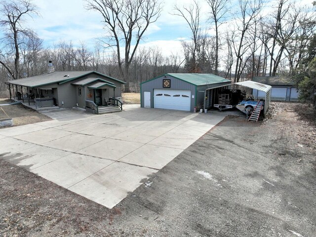 view of property exterior with a garage, an outbuilding, and a carport