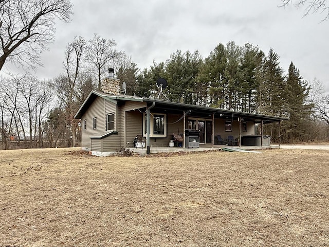 view of front of house featuring a patio area and a hot tub