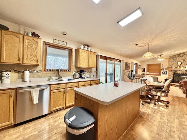 kitchen featuring a healthy amount of sunlight, dishwasher, sink, and a kitchen island