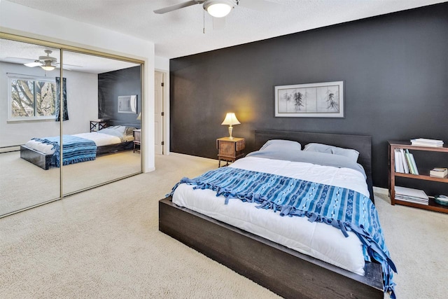 carpeted bedroom featuring a textured ceiling, a closet, and ceiling fan