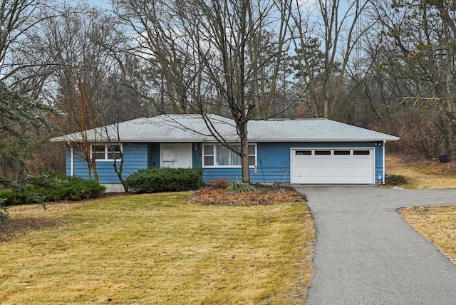 ranch-style home featuring a garage and a front lawn