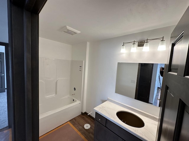 bathroom with vanity, hardwood / wood-style floors, and  shower combination