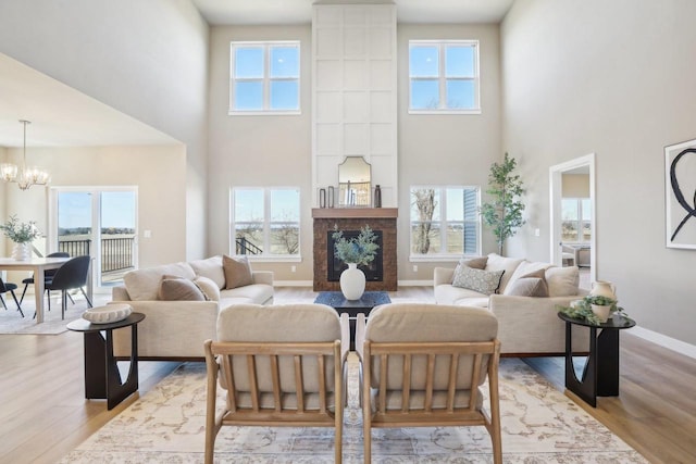 living room with plenty of natural light, light wood-type flooring, and a large fireplace