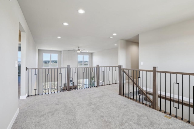 corridor with recessed lighting, baseboards, carpet, and an upstairs landing