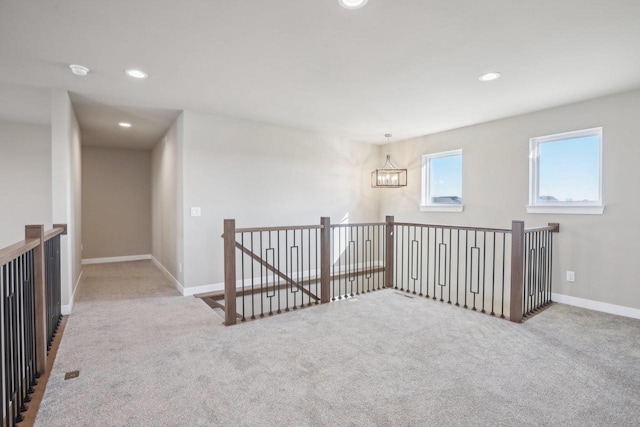 unfurnished room featuring carpet flooring, recessed lighting, an inviting chandelier, and baseboards