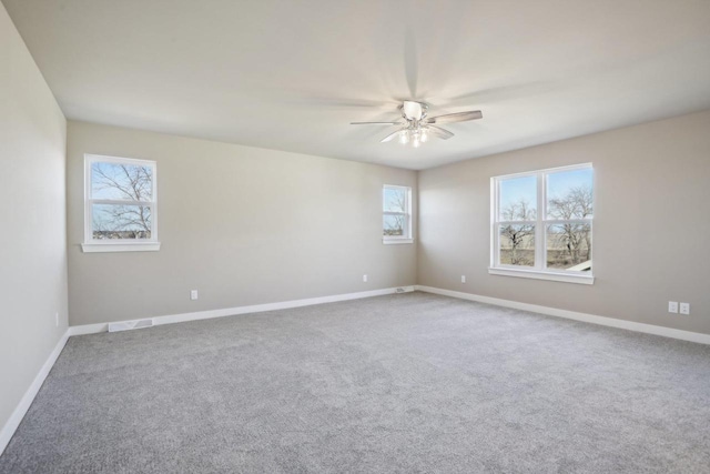 carpeted spare room featuring baseboards and ceiling fan