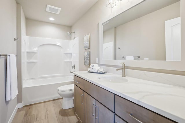 bathroom featuring visible vents, toilet, shower / bath combination, wood finished floors, and vanity