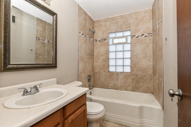 full bathroom featuring vanity, tiled shower / bath, and toilet