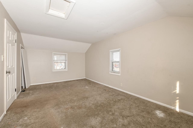 bonus room featuring a healthy amount of sunlight, vaulted ceiling, and carpet