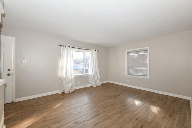 unfurnished room with dark wood-type flooring