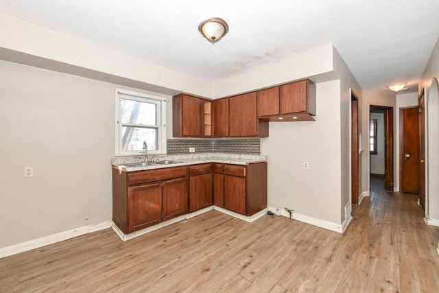 kitchen featuring decorative backsplash, sink, and light hardwood / wood-style flooring