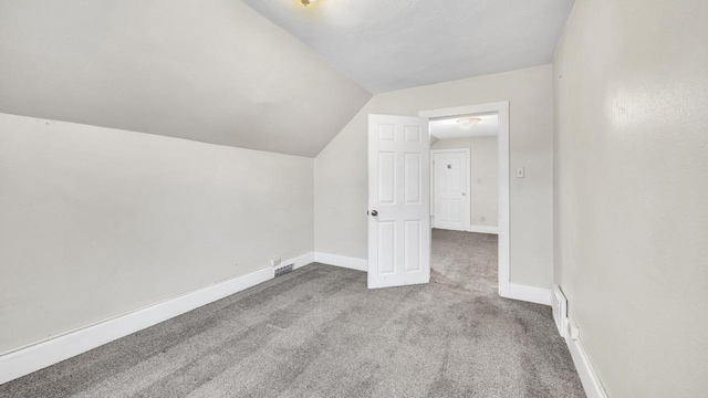 additional living space featuring lofted ceiling and light carpet