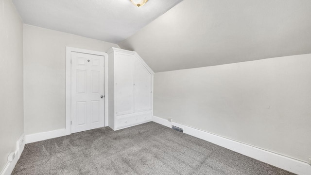 bonus room with vaulted ceiling and carpet