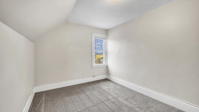 additional living space with vaulted ceiling and carpet flooring